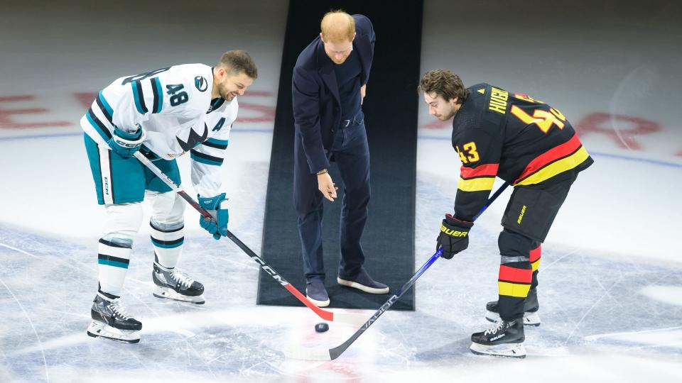 Prince Harry, The Duke of Sussex drops the puck during a ceremonial face-off with Quinn Hughes #43 of the Vancouver Canucks and Tomas Hertl #48 of the San Jose Sharks prior to their NHL game at Rogers Arena 