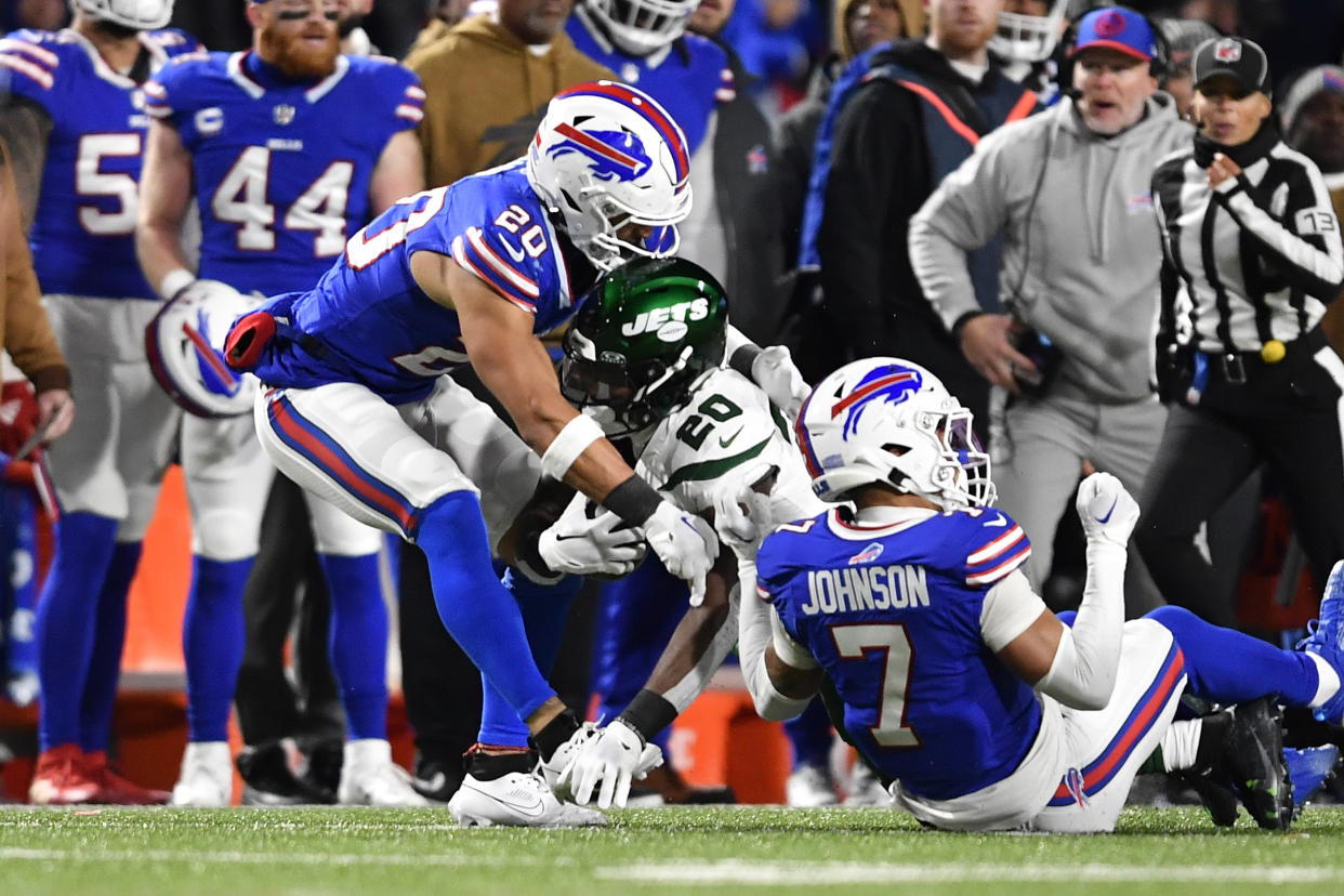 Breece Hall (20), centro, running back de los Jets de Nueva York, es derribado por el safety Taylor Rapp (20) y Taron Johnson (7), de los Bills de Buffalo, durante la primera mitad del partido de la NFL en Orchard Park, Nueva York, el domingo 19 de noviembre de 2023. Rapp y Johnson resultaron lesionados en la jugada. El primero tuvo que ser retirado del campo en ambulancia. (AP Foto/Adrian Kraus)