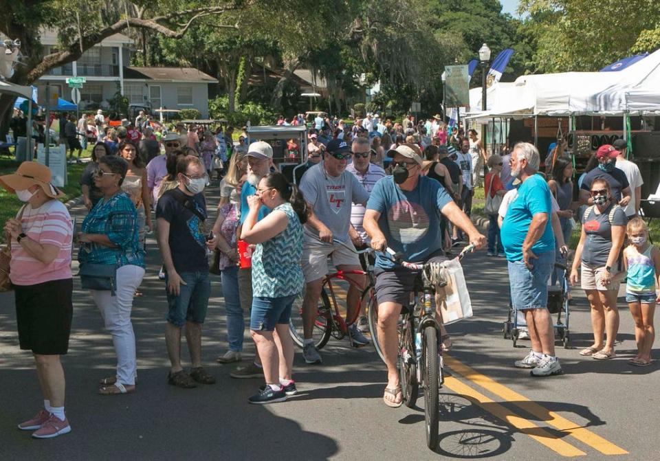 The area in front of the main stage at the Lakeland Public library is crowed as festival attendees stroll along Lake Morton Drive during the annual Mayfaire by-the Lake in Lakeland Saturday. March 9, 2021.