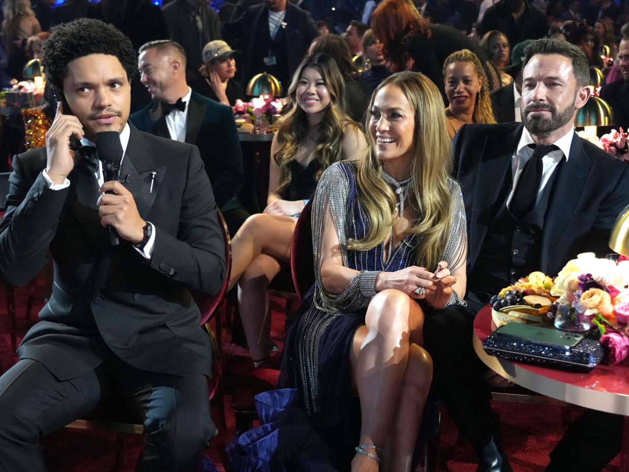 Trevor Noah sitting next to Jennifer Lopez and Ben Affleck