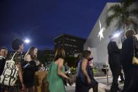 People line up in the entrance plaza of the Santurce Fine Arts Center moments before the premiere of the award-winning Broadway musical, Hamilton, starring its creator, New York native of Puerto Rican descent Lin-Manuel Miranda, in San Juan, Puerto Rico, Friday Jan. 11, 2019. The musical is set to run for two weeks and will raise money for local arts programs. (AP Photo/Carlos Giusti)