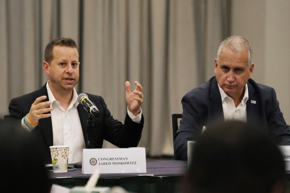 U.S. Congressmen Rep. Jared Moskowitz (D-FL), left, speaks as Mario Diaz-Ballart (R-FL), and others listen during a roundtable discussion, Friday, Aug. 4, 2023, in Parkland, Fla. Earlier in the day the group toured the blood-stained and bullet-pocked halls, shortly before ballistics technicians reenact the massacre that left 14 students and three staff members dead in 2018. (AP Photo/Marta Lavandier).