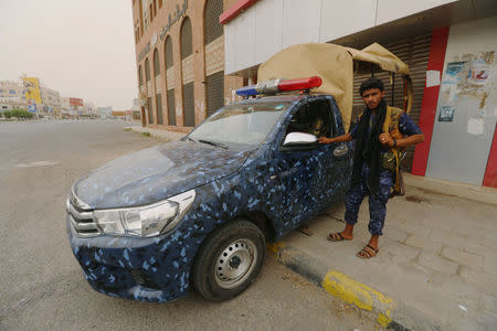 A pro-Houthi police trooper stands next to a patrol vehicle in the Red Sea port city of Hodeidah, Yemen, June 14, 2018. REUTERS/Abduljabbar Zeyad