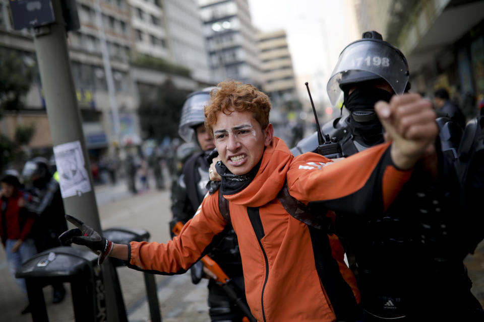 Police detains an anti-government protester in downtown Bogota, Colombia, Friday, Nov. 22, 2019. Colombian President Iván Duque ordered a curfew in the nation's capital amid continuing unrest one day after tens of thousands of people took to the streets in demonstrations during a nationwide strike.(AP Photo/Ivan Valencia)