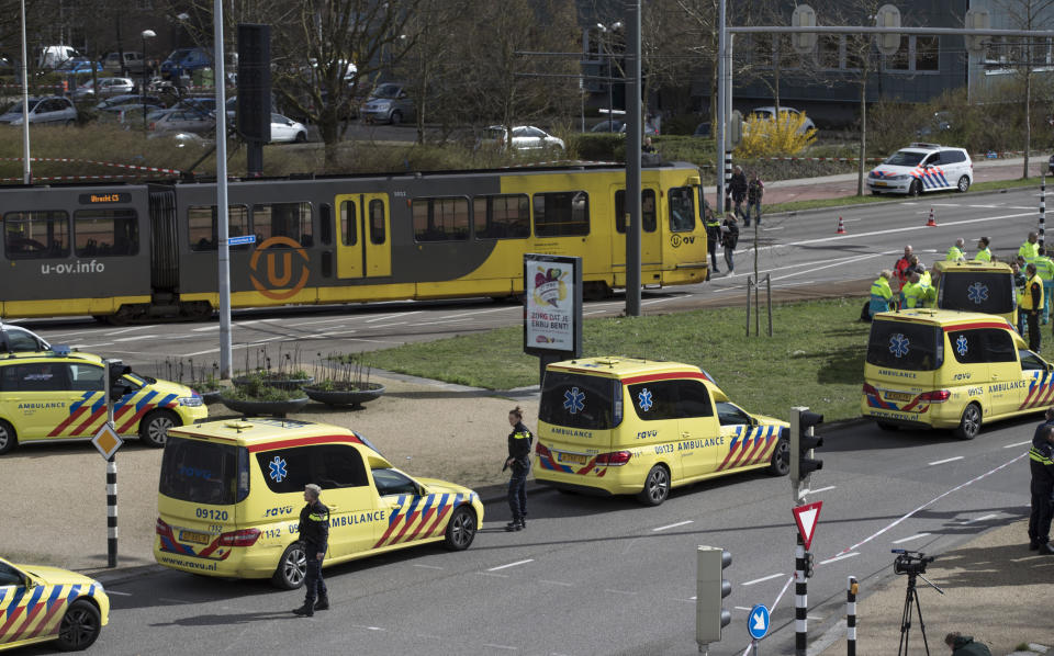 FILE - In this Monday, March 18, 2019 file photo, ambulances are parked next to a tram after a shooting incident in Utrecht, Netherlands. Dutch prosecutors say they have a “strong indication” that a man accused of fatally shooting four passengers on a tram in the central city of Utrecht in March had a “terrorist motive.” Prosecutors say that 37-year-old suspect Gokmen Tanis left a handwritten letter in a getaway car that said in Dutch: “I’m doing this for my religion, you kill Muslims and you want to take our religion away from us, but you won’t succeed.” (AP Photo/Peter Dejong, File)