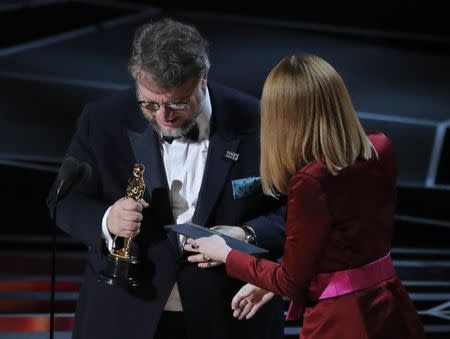 90th Academy Awards - Oscars Show - Hollywood, California, U.S., 04/03/2018 - Guillermo del Toro accepts the Oscar for Best Director for "The Shape of Water" from presenter Emma Stone (R). REUTERS/Lucas Jackson