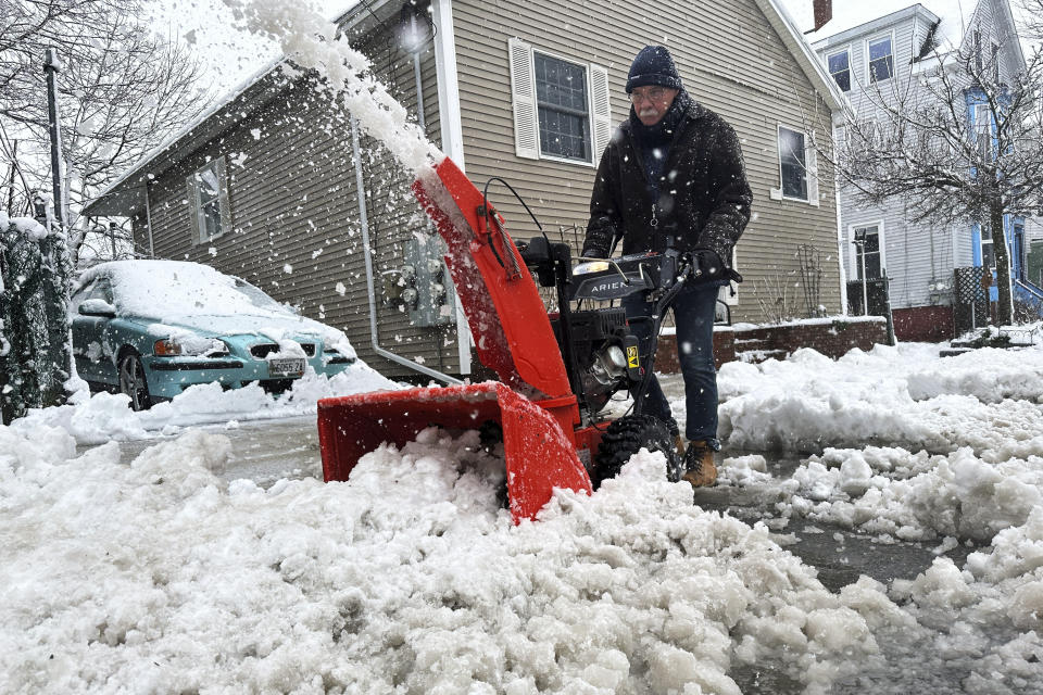 Phil Cloutier removes heavy, wet snow after an early-spring Nor'easter, Thursday, April 4, 2024, in Portland, Maine. (AP Photo/David Sharp)