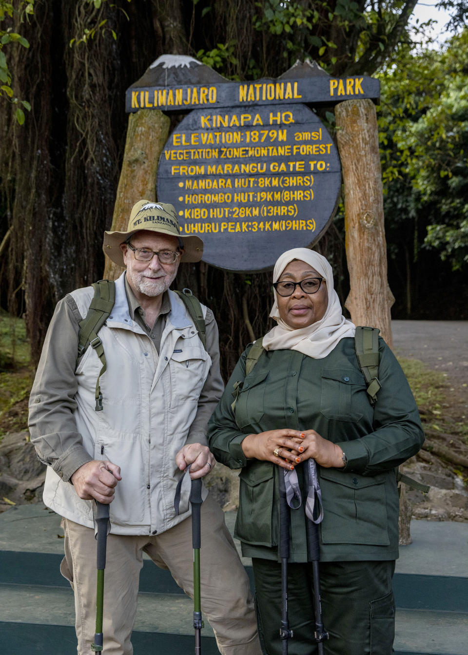 Tanzanian President Samia Suluhu Hassan, right, appears with journalist Peter Greenberg as they begin their trek up Mt. Kilimanjaro for the television show “The Royal Tour.” Greenberg is resuming the series that shows off the best tourist spots of a country and features the nation’s leader as the tour guide. (Karen Ballard via AP)