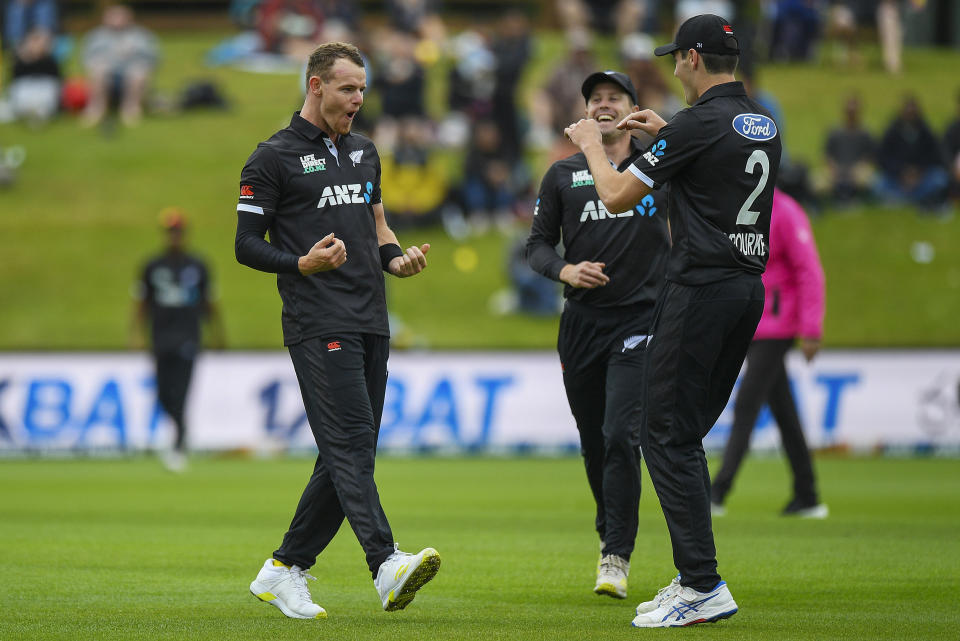 New Zealand's Josh Clarkson, left, celebrates with teammates after taking the wicket of Bangladesh's Anamul Haque during the first One Day cricket international between New Zealand and Bangladesh at University Oval in Dunedin, New Zealand, Sunday, Dec. 17, 2023. (Chris Symes/Photosport via AP)