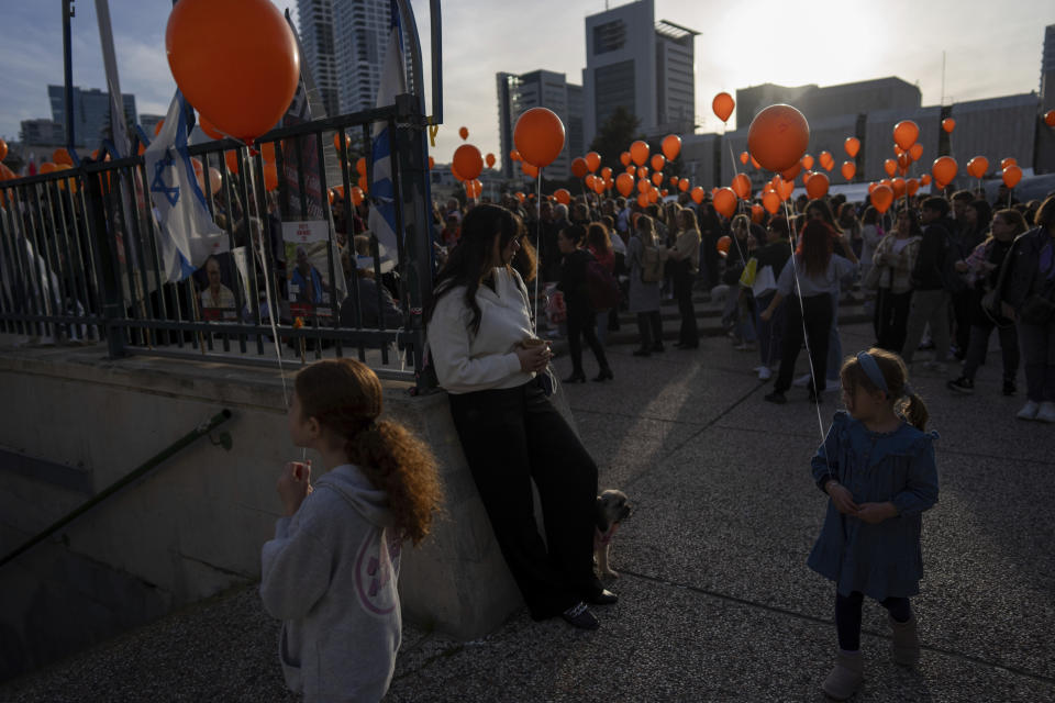 Demonstrators hold orange balloons at a rally in solidarity with Kfir Bibas, an Israeli boy who spent his first birthday Thursday in Hamas captivity in the Gaza Strip, in Tel Aviv, Israel, Thursday, Jan. 18, 2024. The plight of Bibas, the youngest hostage held by Hamas, has captured the nation's attention and drawn attention to the government's failure to bring home more than 100 hostages still held by Hamas after more than three months of war. (AP Photo/Oded Balilty)