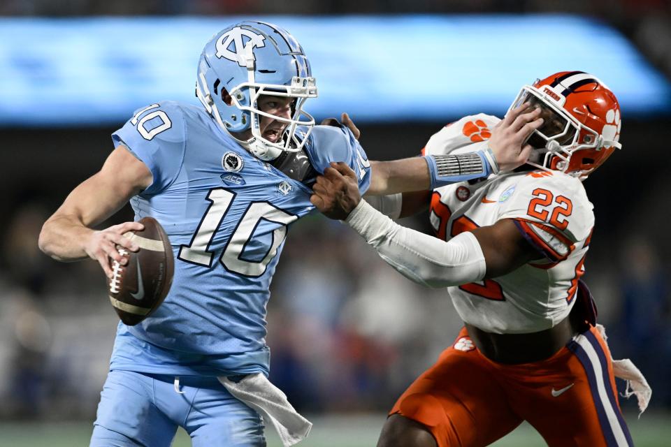 CHARLOTTE, NORTH CAROLINA - DECEMBER 03: Drake Maye #10 of the North Carolina Tar Heels gets called for a facemask penalty against Trenton Simpson #22 of the Clemson Tigers in the second quarter during the ACC Championship game at Bank of America Stadium on December 03, 2022 in Charlotte, North Carolina. (Photo by Eakin Howard/Getty Images)