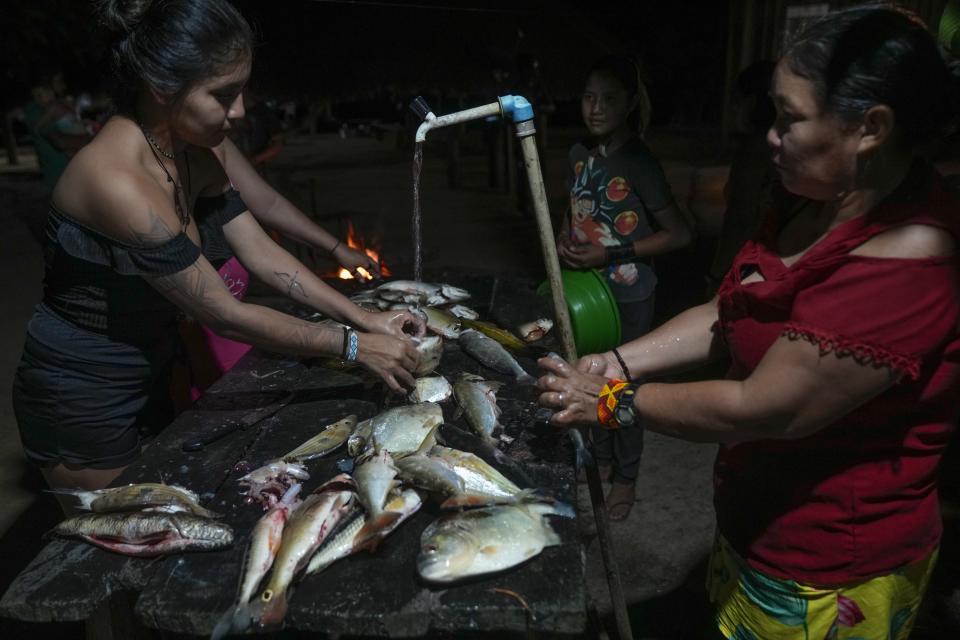 Juma Indigenous women prepare the day’s catch in their community, near Canutama, Amazonas state, Brazil, Saturday, July 8, 2023. The Juma seemed destined to disappear following the death of the last remaining elderly man, but under his three daughters’ leadership, they changed the patriarchal tradition and now fight to preserve their territory and culture. (AP Photo/Andre Penner)