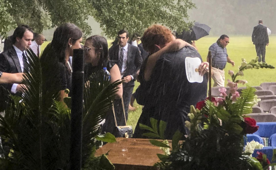 Buster Murdaugh, center, receives a hug in the rain during the funeral service for his brother, Paul, and mother, Maggie, on Friday, June 11, 2021 in Hampton, South Carolina. / Credit: Kacen Bayless/The Island Packet via AP