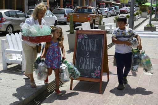 A Uruguayan woman and her grandchildren take plastic bottles to a collection center in Priapolis on January 22