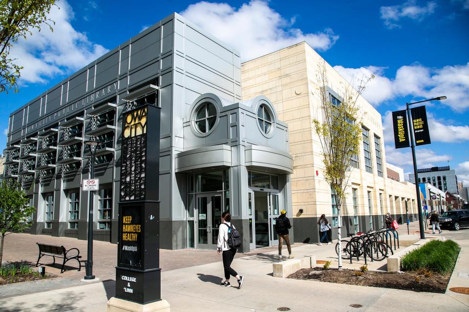 People walk past the Iowa City Public Library in 2021, on the corner of College and Linn streets. The library will host a history walk at 5 p.m. Friday.