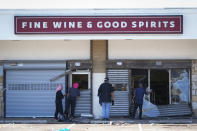 People view a ransacked liquor store in Philadelphia, Wednesday, Sept. 27, 2023. Police say groups of teenagers swarmed into stores across Philadelphia in an apparently coordinated effort, stuffed bags with merchandise and fled. (AP Photo/Matt Rourke)