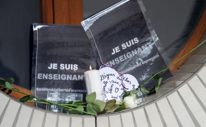 Flowers, a candle and a message are seen in front of the Bois d'Aulne college after the attack in the Paris suburb of Conflans St Honorine