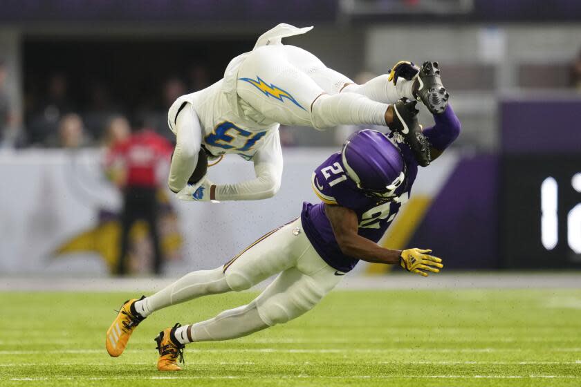 Chargers receiver Keenan Allen (13) is tackled by Vikings cornerback Akayleb Evans (21) after catching a pass.