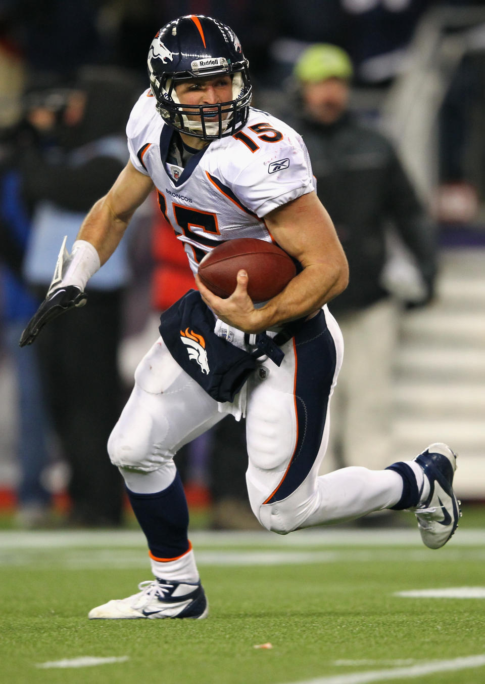 FOXBORO, MA - JANUARY 14: Tim Tebow #15 of the Denver Broncos runs with the ball against the New England Patriots during their AFC Divisional Playoff Game at Gillette Stadium on January 14, 2012 in Foxboro, Massachusetts. It was reported that the New York Jets have traded a fourth-round pick for quarterback Tim Tebow of the Denver Broncos March 21, 2012. (Photo by Al Bello/Getty Images)