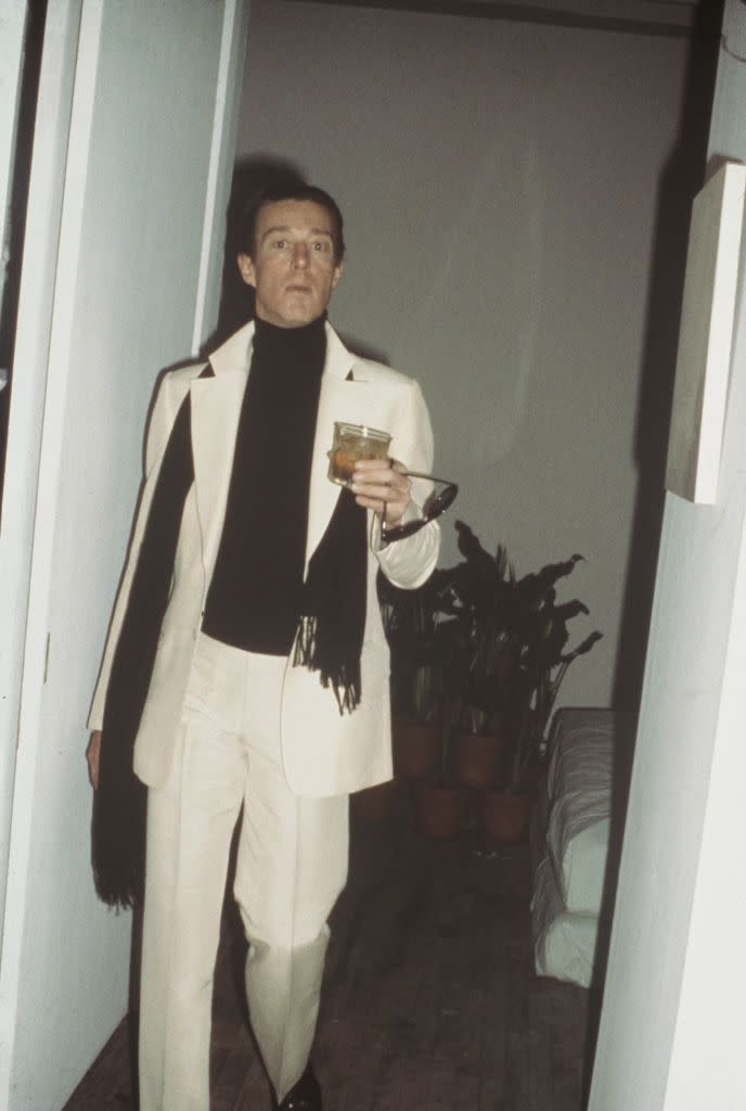 <p>Here, Halston is photographed candidly in a chic suit and black turtleneck.</p>