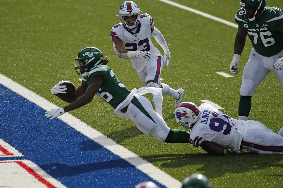 New York Jets running back Josh Adams (36) falls into the endzone for a touchdown while in the grasp of Buffalo Bills defensive tackle Ed Oliver (91) during the second half of an NFL football game in Orchard Park, N.Y., Sunday, Sept. 13, 2020. The Bills won 27-17. (AP Photo/John Munson)