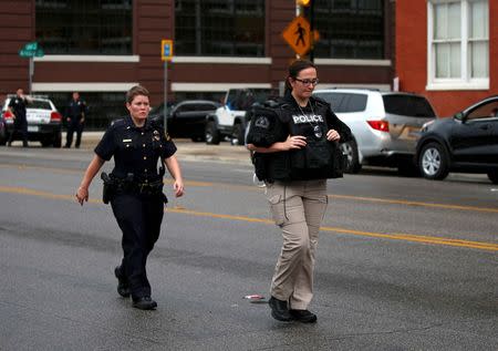 Dallas police officers walk in front of the Dallas Police Department headquarters after an anonymous threat was reported in Dallas, Texas, U.S. July 9, 2016. REUTERS/Carlo Allegri