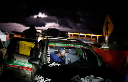 Venezuelan people are pictured inside a taxi before traveling towards Boa Vista city, after checking their passports or identity cards at the Pacaraima border control, Roraima state, Brazil August 19, 2018. REUTERS/Nacho Doce