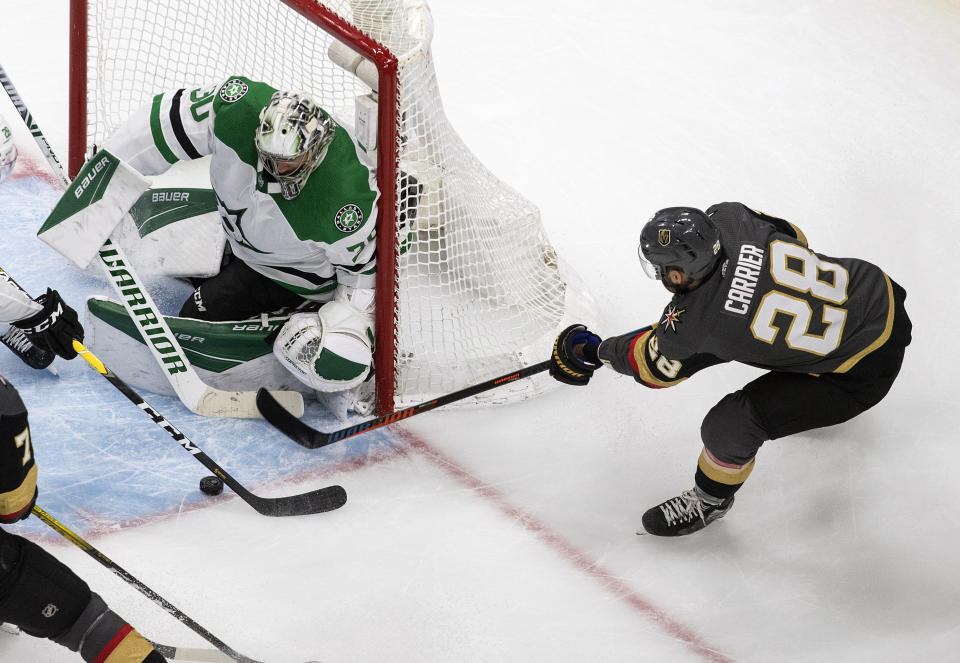 Dallas Stars goalie Ben Bishop (30) makes the save on Vegas Golden Knights' William Carrier (28) during the third period of an NHL hockey playoff game Monday, Aug. 3, 2020 in Edmonton, Alberta. (Jason Franson/The Canadian Press via AP)