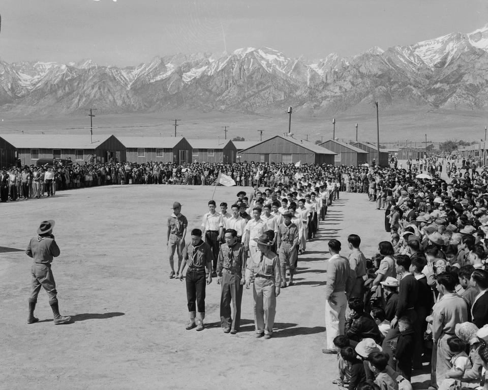 In this photo provided by the National Archives, Japanese Americans, including American Legion members and Boy Scouts, participate in Memorial Day services at the Manzanar Relocation Center, an internment camp in Manzanar, Calif., on May 31, 1942. (Francis Leroy Stewart/War Relocation Authority/National Archives via AP)