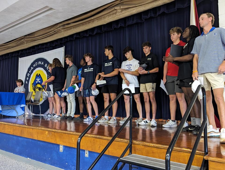 Fernandina Beach's 12 spring signees line up on stage during a college athletic signing ceremony on May 1, 2024. [Clayton Freeman/Florida Times-Union]