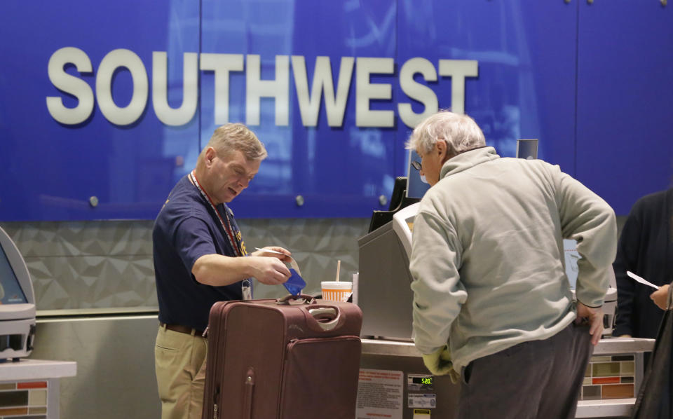 FILE - In this Feb. 3, 2014 file photo, a passenger checks in luggage at the Southwest Airlines counter at Love Field in Dallas. British billionaire Richard Branson on Tuesday, May 6, 2014 said that Virgin America should get gates at Love Field, near downtown Dallas, to create competition for Southwest Airlines, which controls most of the gates there. The U.S. Justice Department agrees. (AP Photo/LM Otero, File)