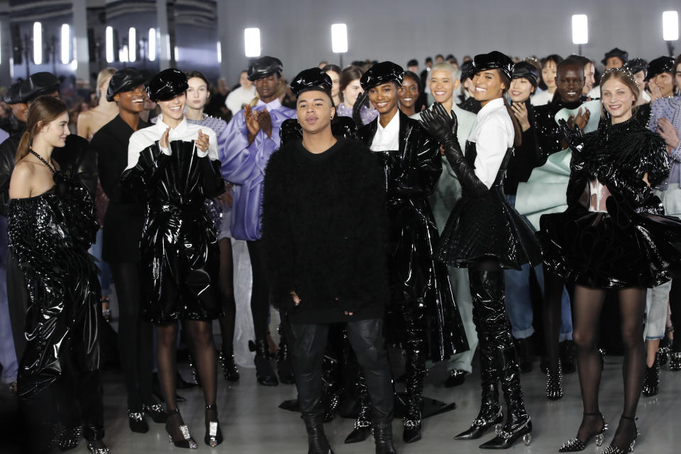 Designer Olivier Rousteing, centre, poses with models at the conclusion of the Balmain ready to wear Fall-Winter 2019-2020 collection, that was presented in Paris, Friday, March 1, 2019. (AP Photo/Christophe Ena)