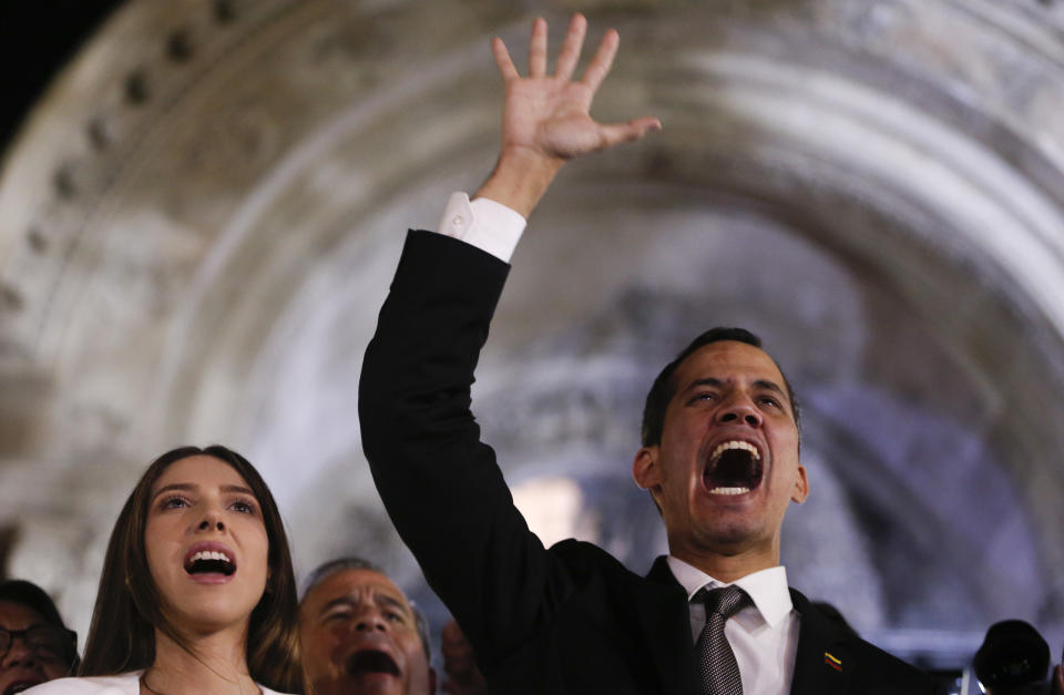 Accompanied by his wife Fabiana Rosales, Venezuela's self-proclaimed interim president Juan Guaido waves to supporters outside the Foreign Ministry in Buenos Aires, Argentina, Friday, March 1, 2019. Guaido is in tour of several South American capitals as part of a campaign to build international pressure on his rival Nicolas Maduro to quit. (AP Photo/Natacha Pisarenko)