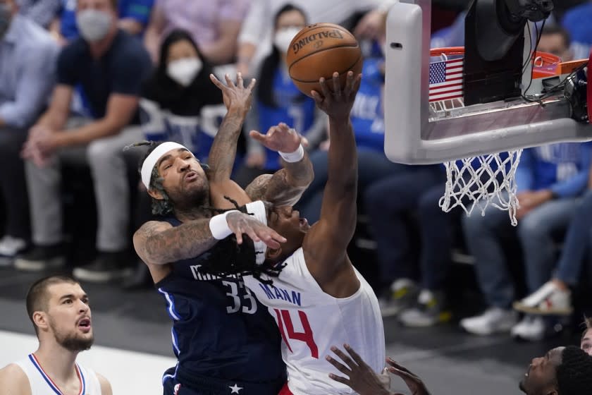 Dallas Mavericks center Willie Cauley-Stein (33) fouls Los Angeles Clippers guard Terance Mann (14) on a shot attempt in the first half in Game 3 of an NBA basketball first-round playoff series in Dallas, Friday, May 28, 2021. (AP Photo/Tony Gutierrez)