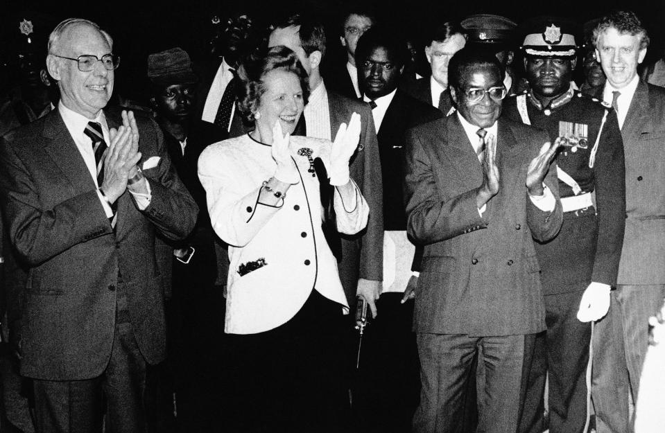 <p>British Prime Minister Margaret Thatcher, accompanied by her husband, arrives at Harare International Airport for a two-day visit to Zimbabwe on March 29, 1981. Thatcher with her husband and Zimbabwean President Robert Mugabe applauded the traditional dancers who greeted them as they stepped off their plane. (Photo: Peter Winterbach/AP) </p>