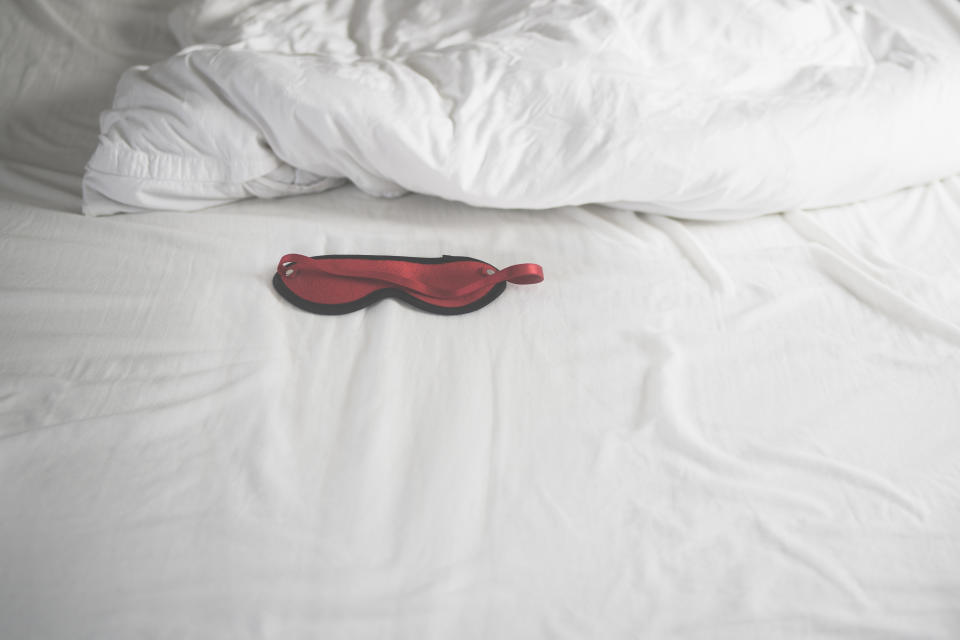 sex mask on empty white bed