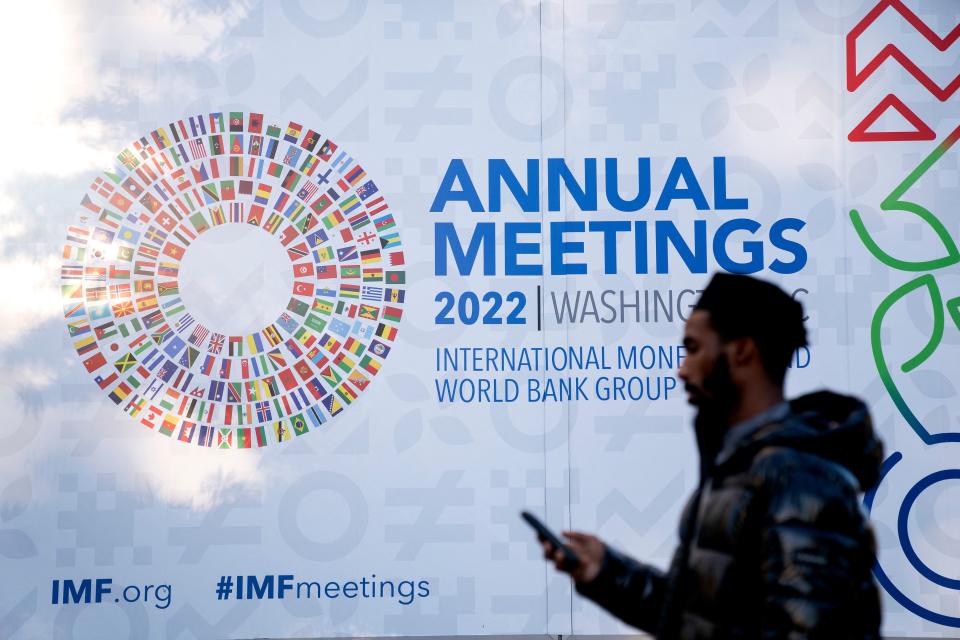 A pedestrian walks past a sign for the International Monetary Fund (IMF) annual Fall Meetings in Washington, DC, on October 8, 2022. - The IMF will be hosting its annual Fall Meetings in Washington DC from October 10 through October 16. (Photo by Stefani Reynolds / AFP) (Photo by STEFANI REYNOLDS/AFP via Getty Images)
