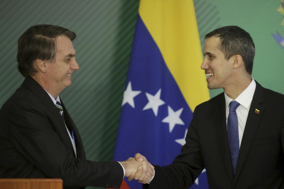 Brazil's President Jair Bolsonaro, left, and Venezuela's self-proclaimed interim president Juan Guaido shake hands during a joint statement in Brasilia, Brazil, Thursday, Feb.28, 2019. Guaido met Bolsonaro, who recognizes Guaido and has taken a hard line against Venezuelan President Nicolas Maduro. (AP Photo/Lucio Tavora)