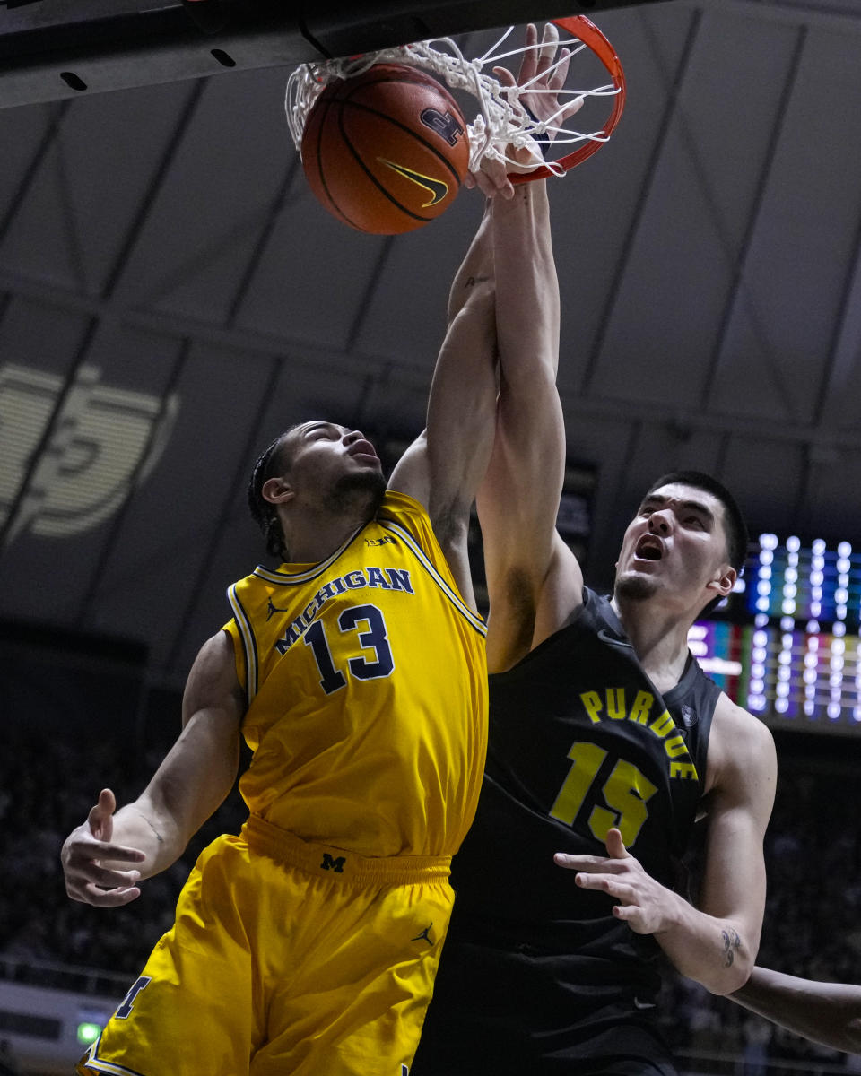 Purdue center Zach Edey (15) is fouled on a dunk over Michigan forward Olivier Nkamhoua (13) during the second half of an NCAA college basketball game in West Lafayette, Ind., Tuesday, Jan. 23, 2024. (AP Photo/Michael Conroy)