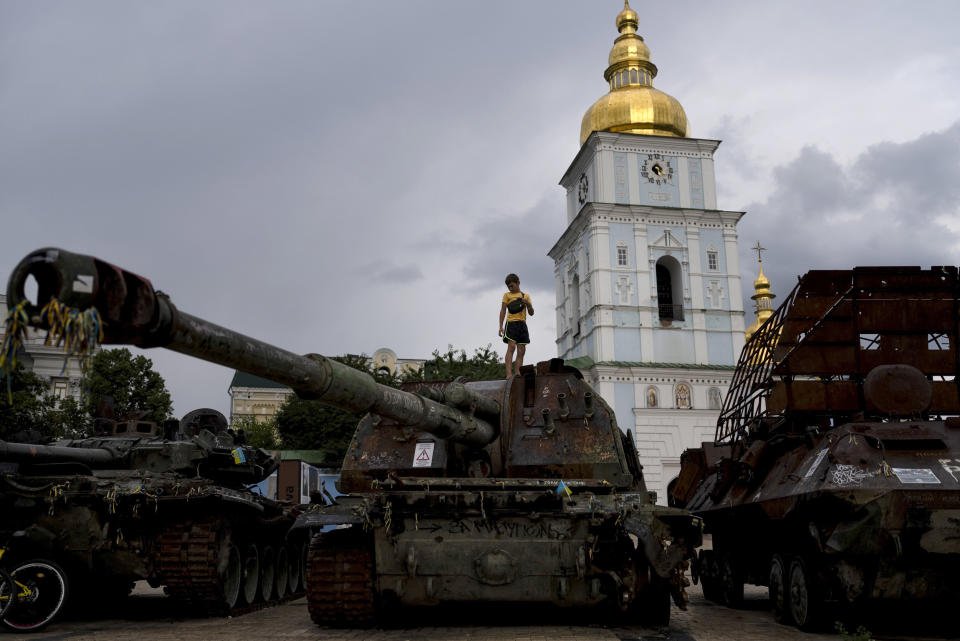 Image: A boy stands atop destroyed Russian tanks on display in Kyiv on June 30. (Jae C. Hong / AP file)