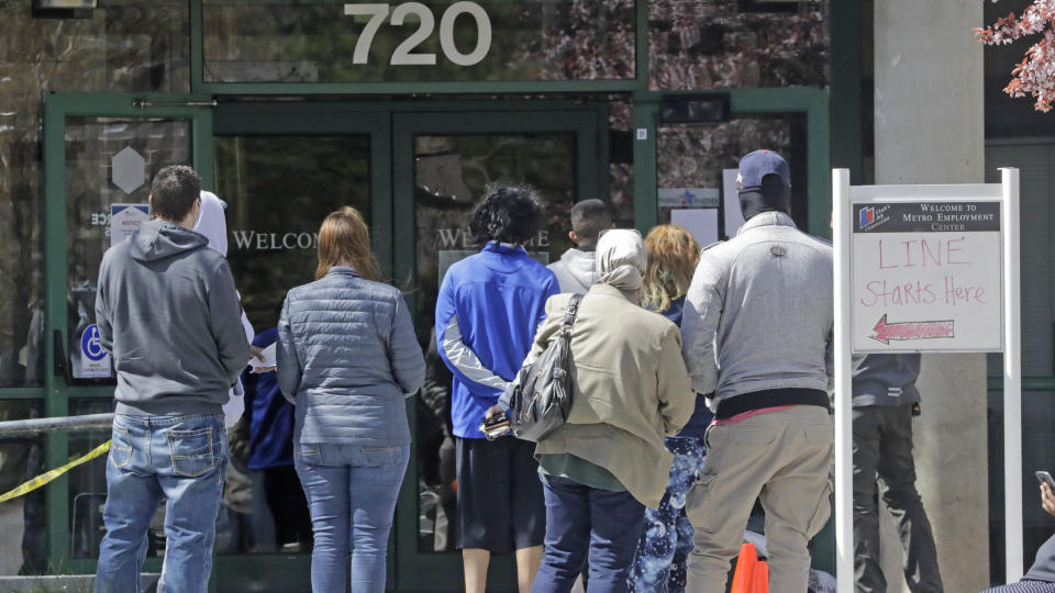 People line up outside the Utah Department of workforce Services Monday, April 13, 2020, in Salt Lake City. Congress, the Trump administration and the Federal Reserve have mounted the largest financial intervention in history a full-scale drive that includes mandating sick leave for some, distributing $1,200 checks to individuals, allocating rescue aid to employers and expanding unemployment benefits to try to help America survive the crisis. Yet those measures are only temporary. And for millions of newly unemployed, they may not be enough. (AP Photo/Rick Bowmer)