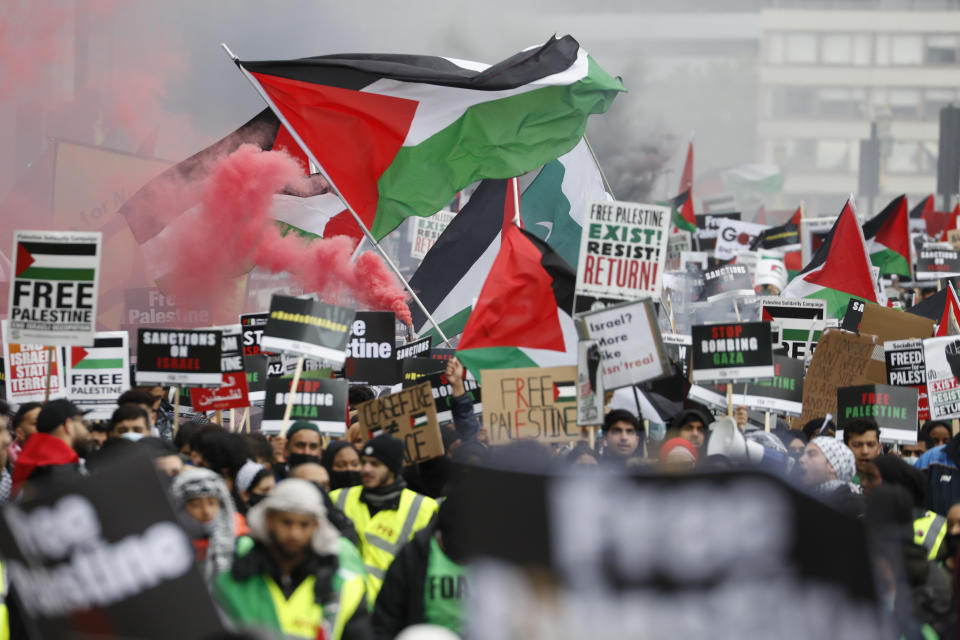 Protesters hold placards and banners in London, Saturday, May 22, 2021, as they take part in a rally supporting Palestinians. Egyptian mediators held talks Saturday to firm up an Israel-Hamas cease-fire as Palestinians in the Hamas-ruled Gaza Strip began to assess the damage from 11 days of intense Israeli bombardment. (AP Photo/Alastair Grant)