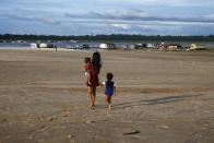 FILE - Children walk in an area impacted by the drought near the Solimoes River, in Tefe, Amazonas state, Brazil, Oct. 19, 2022. (AP Photo/Edmar Barros, File)