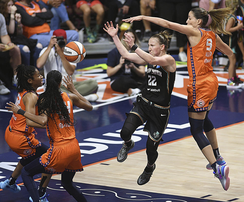 Connecticut Sun's Rebecca Allen (9) attempts to block a pass from New York Liberty's Courtney Vandersloot (22) during a WNBA basketball game Thursday, Aug. 24, 2023, in Uncasville, Conn. (Sarah Gordon/The Day via AP)