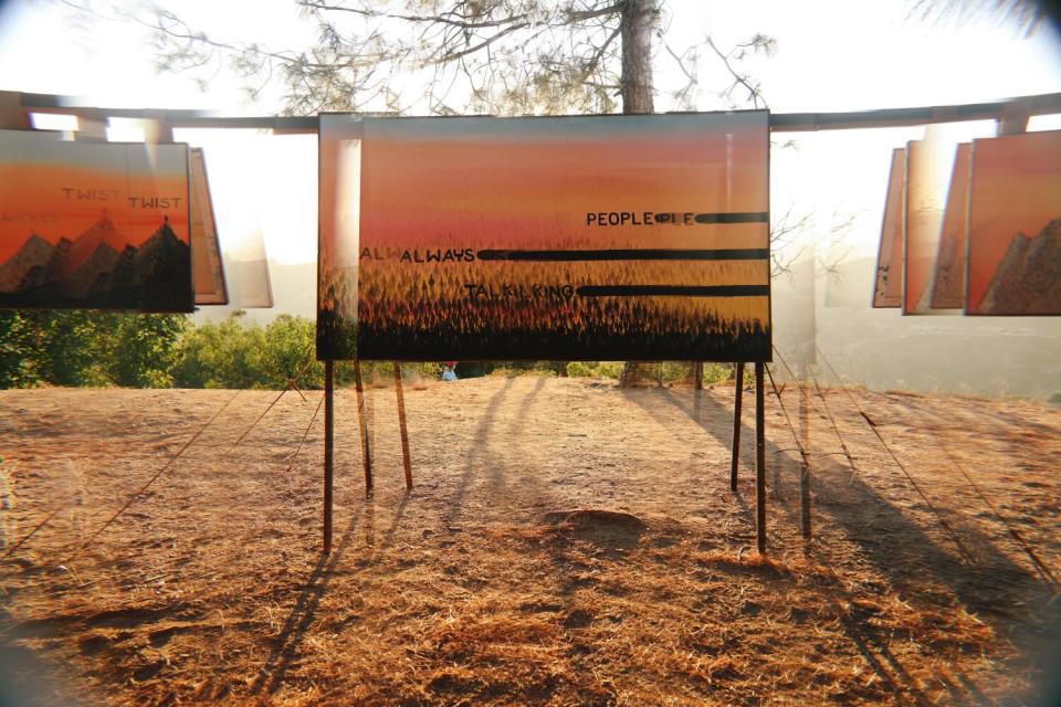 Artwork by Senon Williams on a wooden rig at sunset.