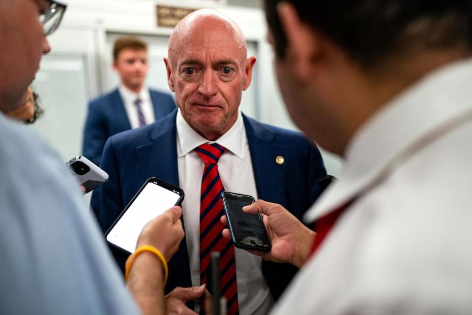 PHOTO: Sen. Mark Kelly speaks with reporters while waiting to catch the Senate subway to the Hart Senate Office Building from the Capitol, July 25, 2024. (Kent Nishimura/Getty Images)