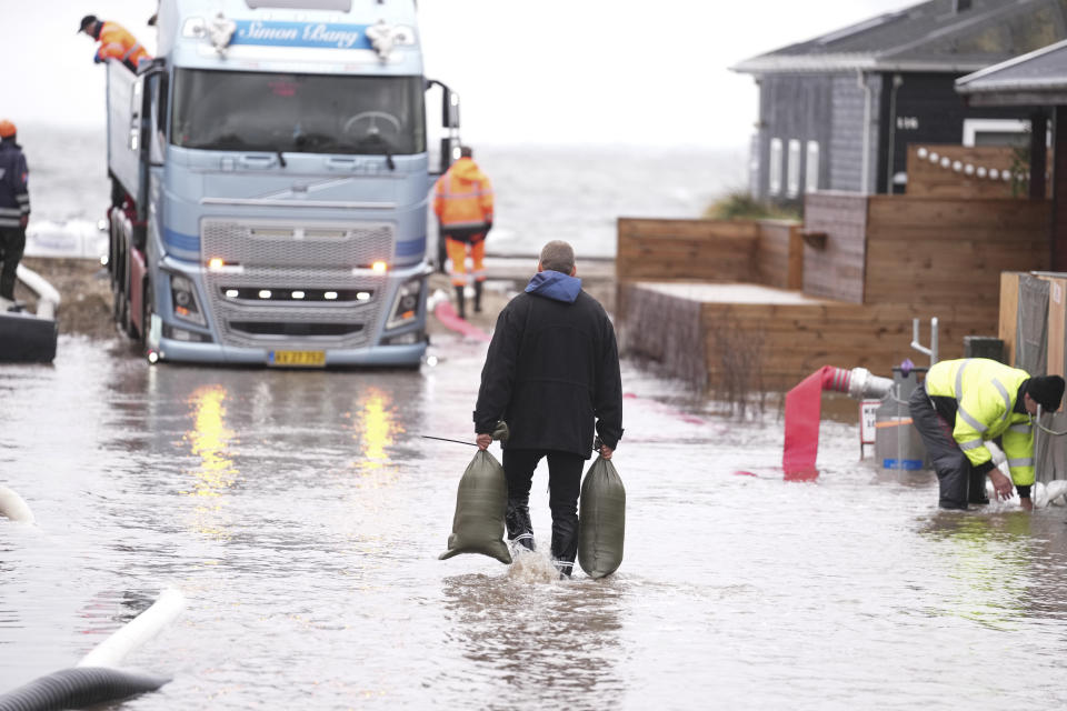 Residents and members of the the Emergency Management Agency prepare for the heavy wind and increased water levels, at Kelstrup Strand, in Haderslev southern, Denmark Thursday, Oct. 19, 2023. Southern Scandinavia and northern Germany braced for bad weather with gale force winds over the next days. Authorities said Thursday that floods could cause major problems in inner Danish waters and in the Baltic Sea. (Claus Fisker/Ritzau Scanpix via AP)