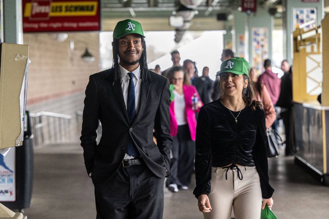 DaSean Spencer and Sierra Zavala of the Greater Sacramento Economic Council wear Oakland Athletics caps as they walk in the concourse at Sutter Health Park on Thursday, after the announcement that the A’s will temporarily relocate to West Sacramento in 2025.