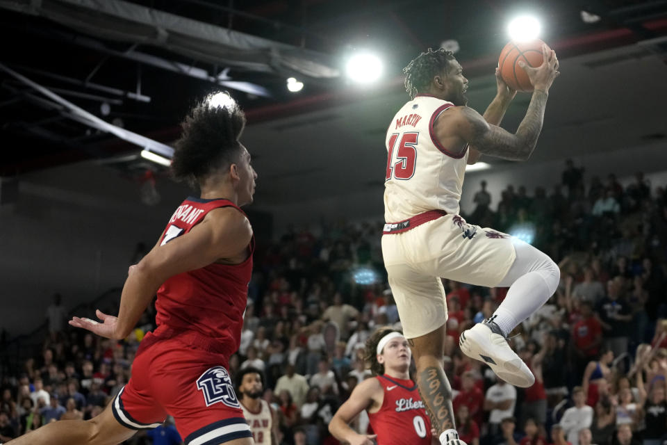 Florida Atlantic guard Alijah Martin (15) goes to the basket as Liberty guard Joseph Venzant, left, defends during the first half of an NCAA college basketball game, Thursday, Nov. 30, 2023, in Boca Raton, Fla. (AP Photo/Lynne Sladky)