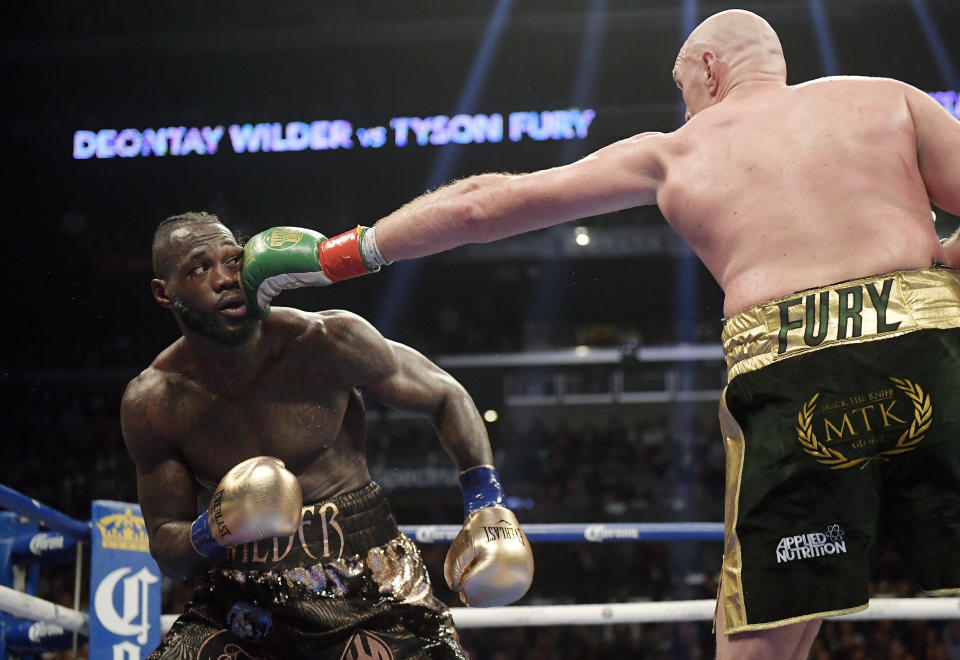 Tyson Fury, right, of England, connects with Deontay Wilder during a WBC heavyweight championship boxing match, Saturday, Dec. 1, 2018, in Los Angeles. (AP Photo/Mark J. Terrill)